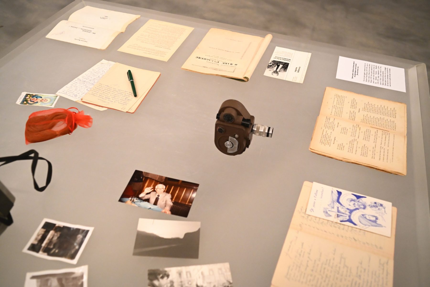 Manoscritti, una penna stilografica, fotografie e una cinepresa dentro la teca